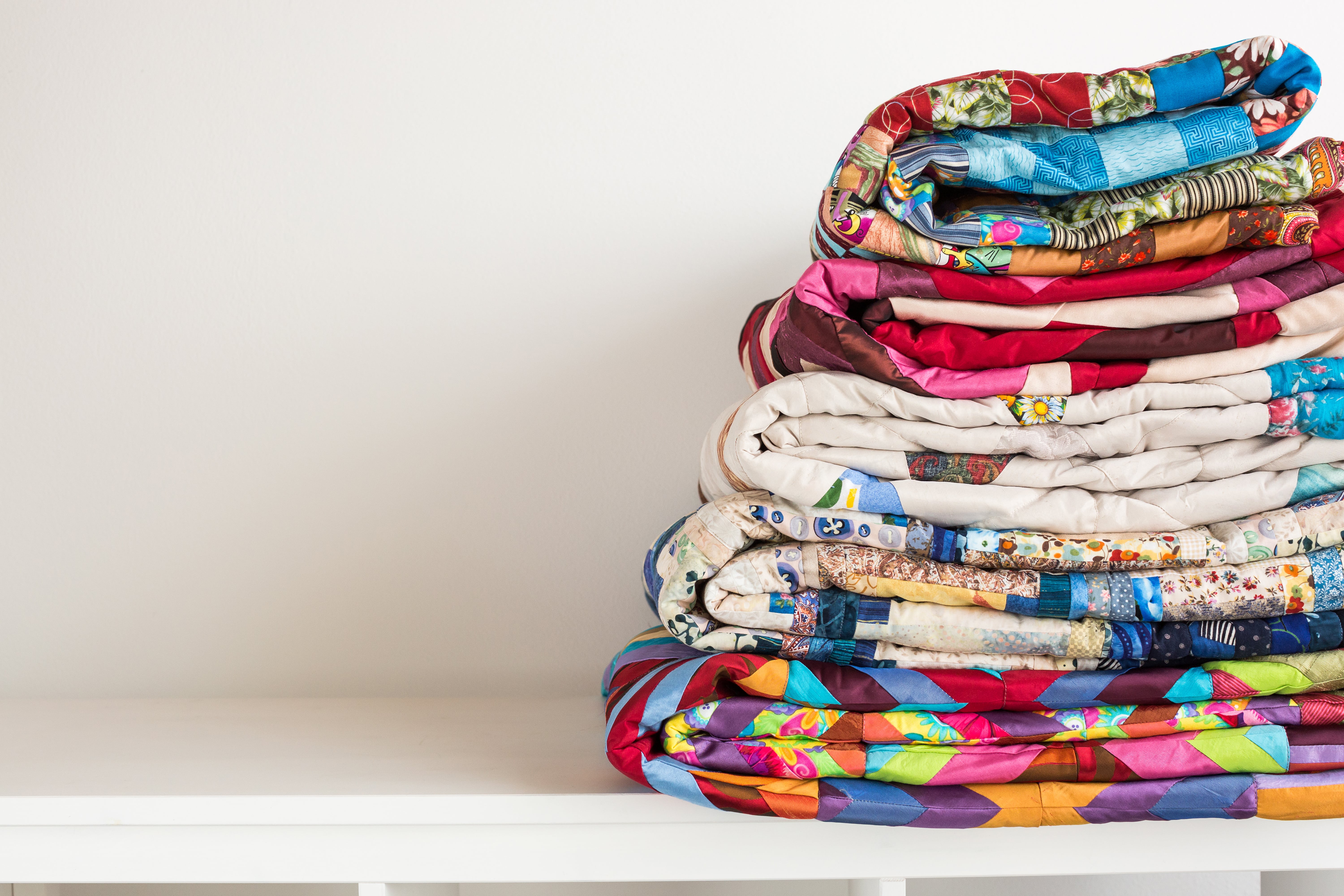 Stack of colourful folded quilts