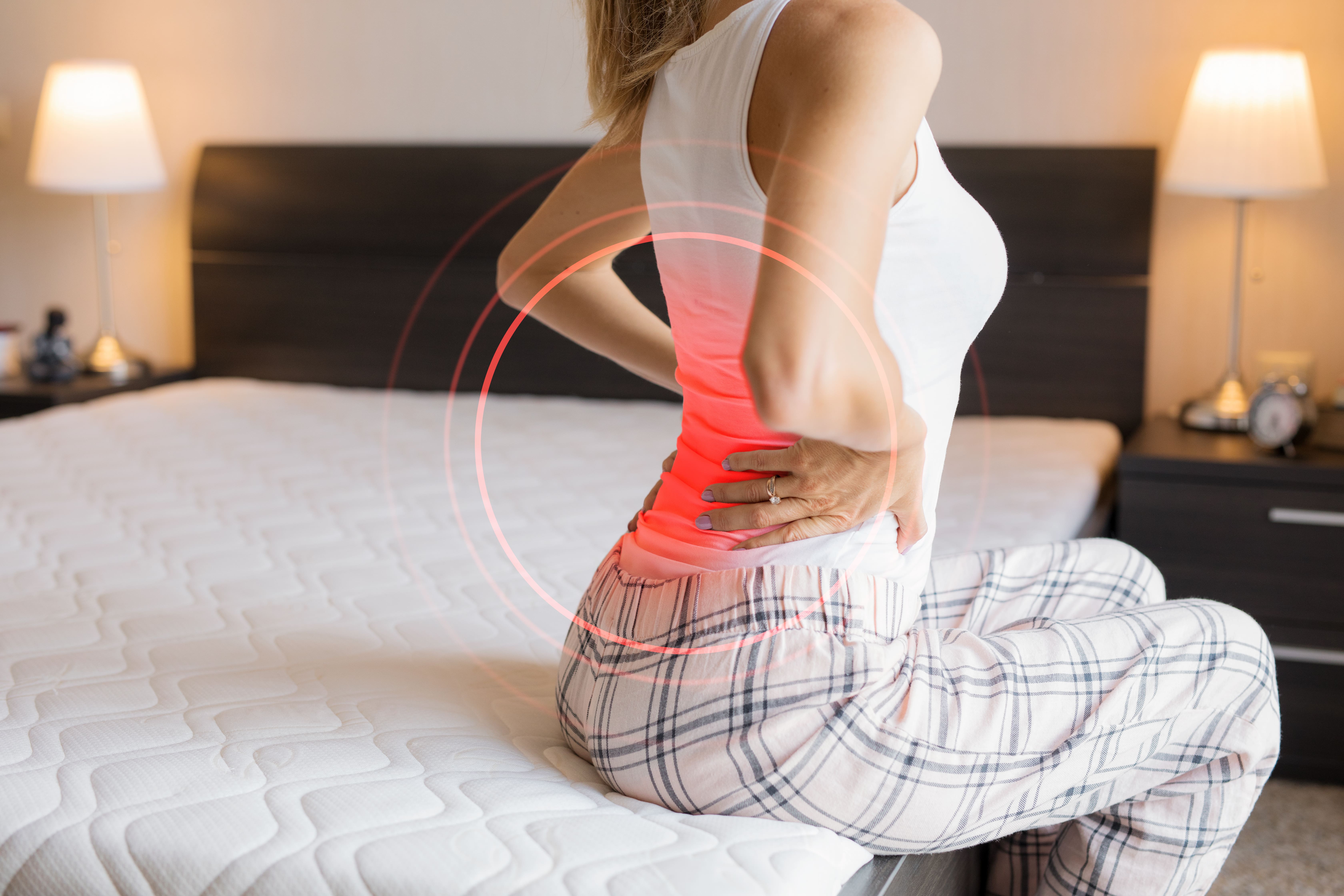 A woman stretching her back. A red circle indicates she has lower back pain. 