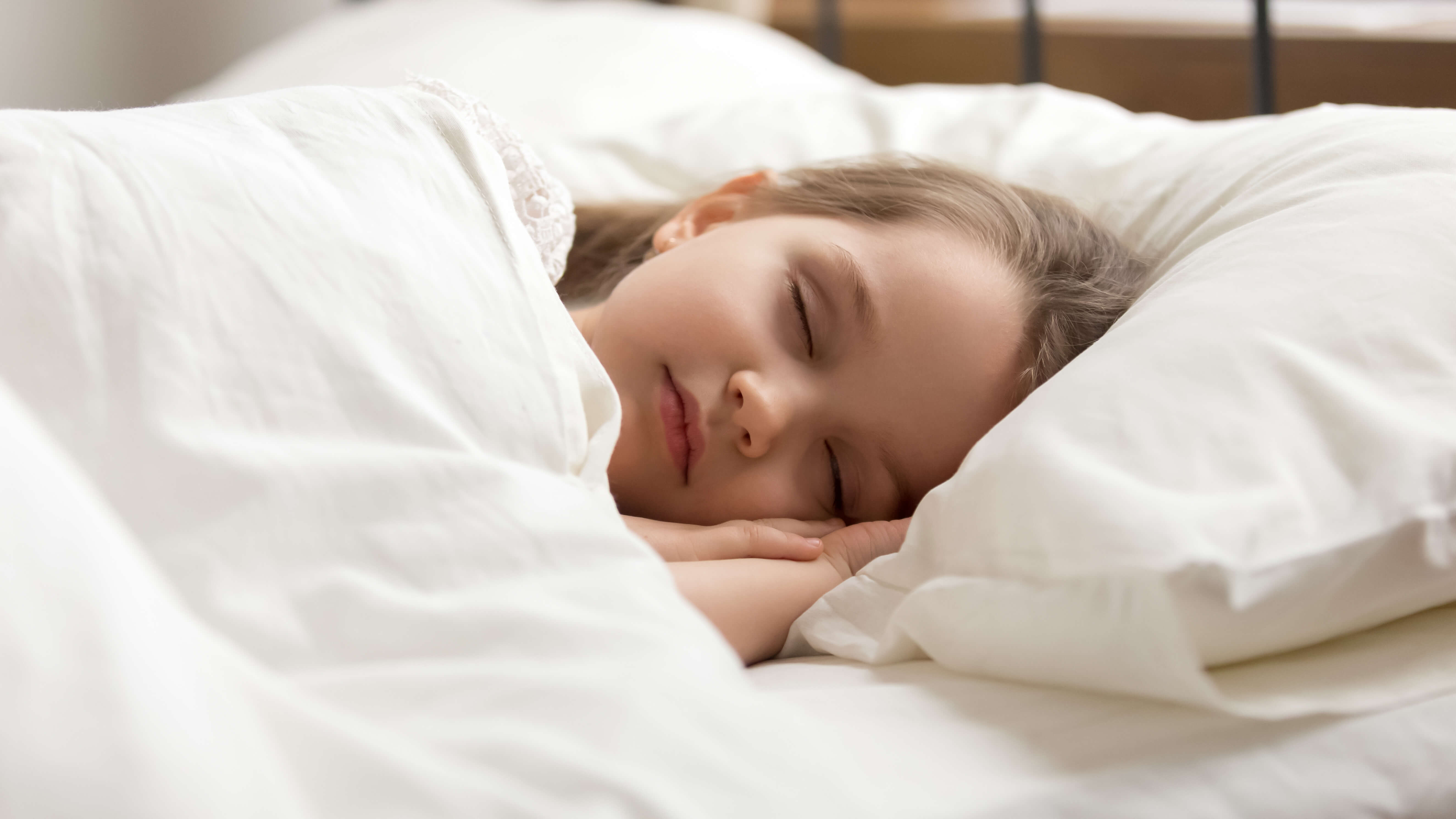 A little girl asleep on a single mattress