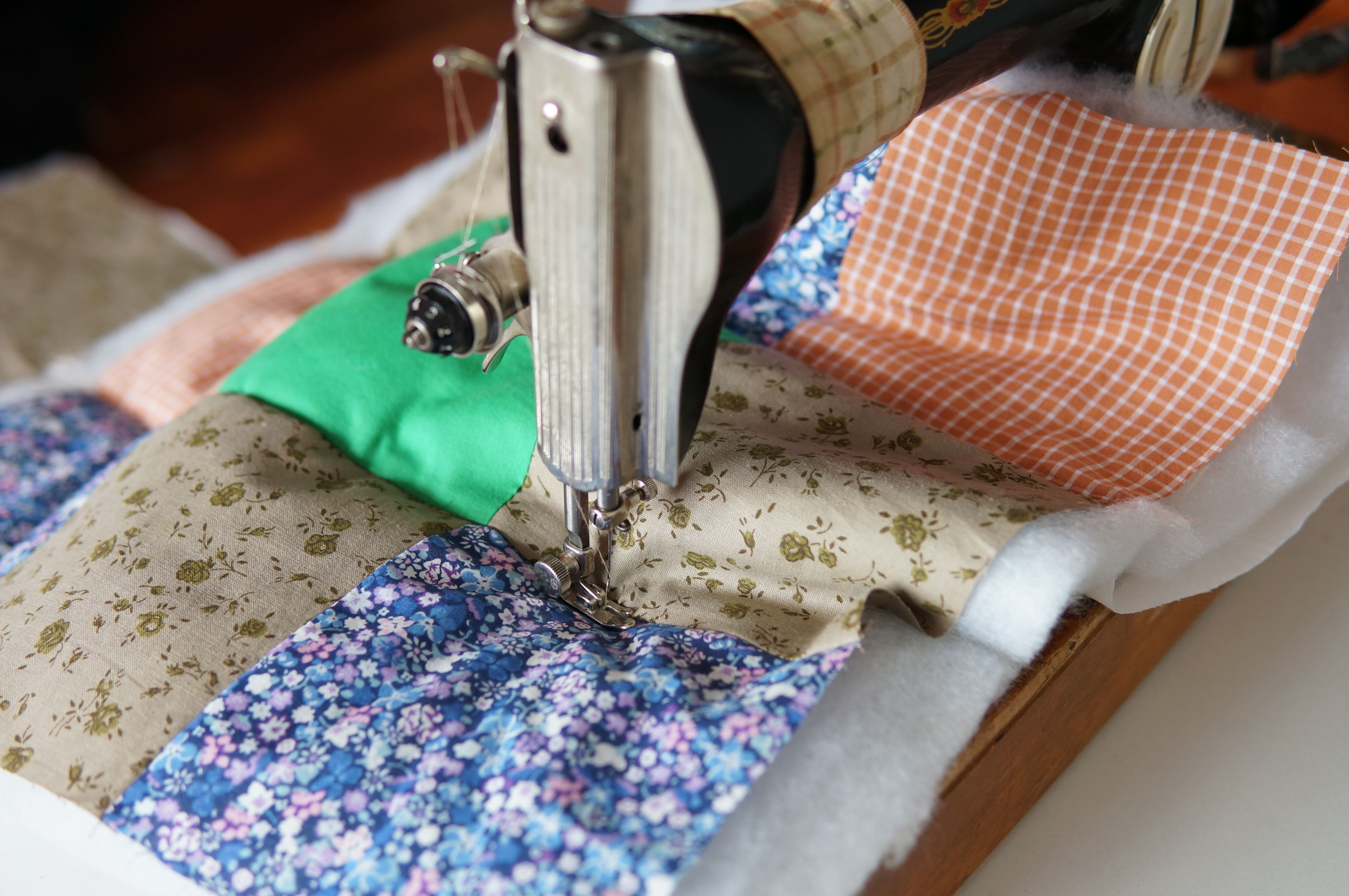 A colourful patchwork quilt being made on an old-fashioned sewing machine