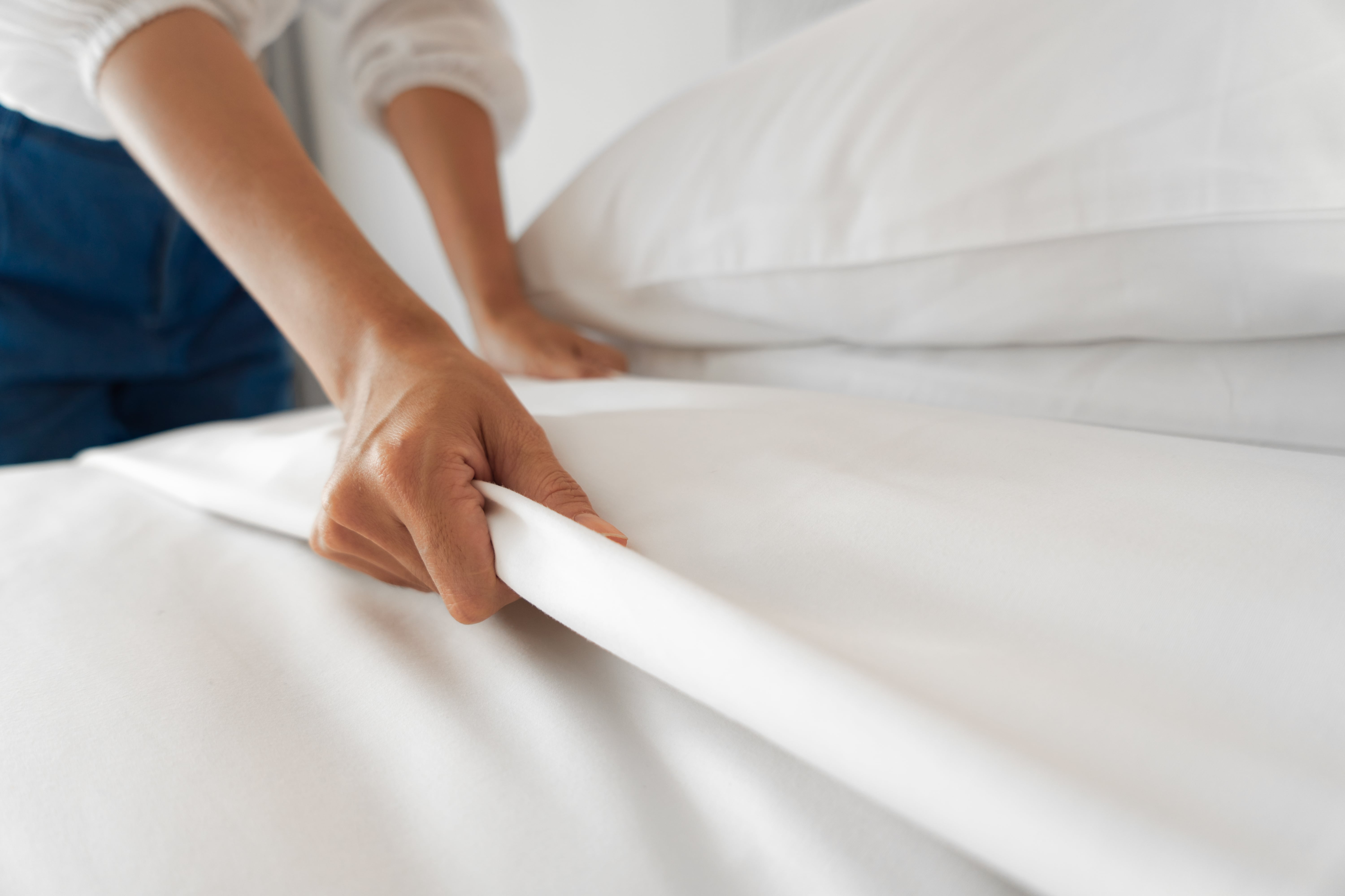 Woman's Hands Turning Down Bed Sheets