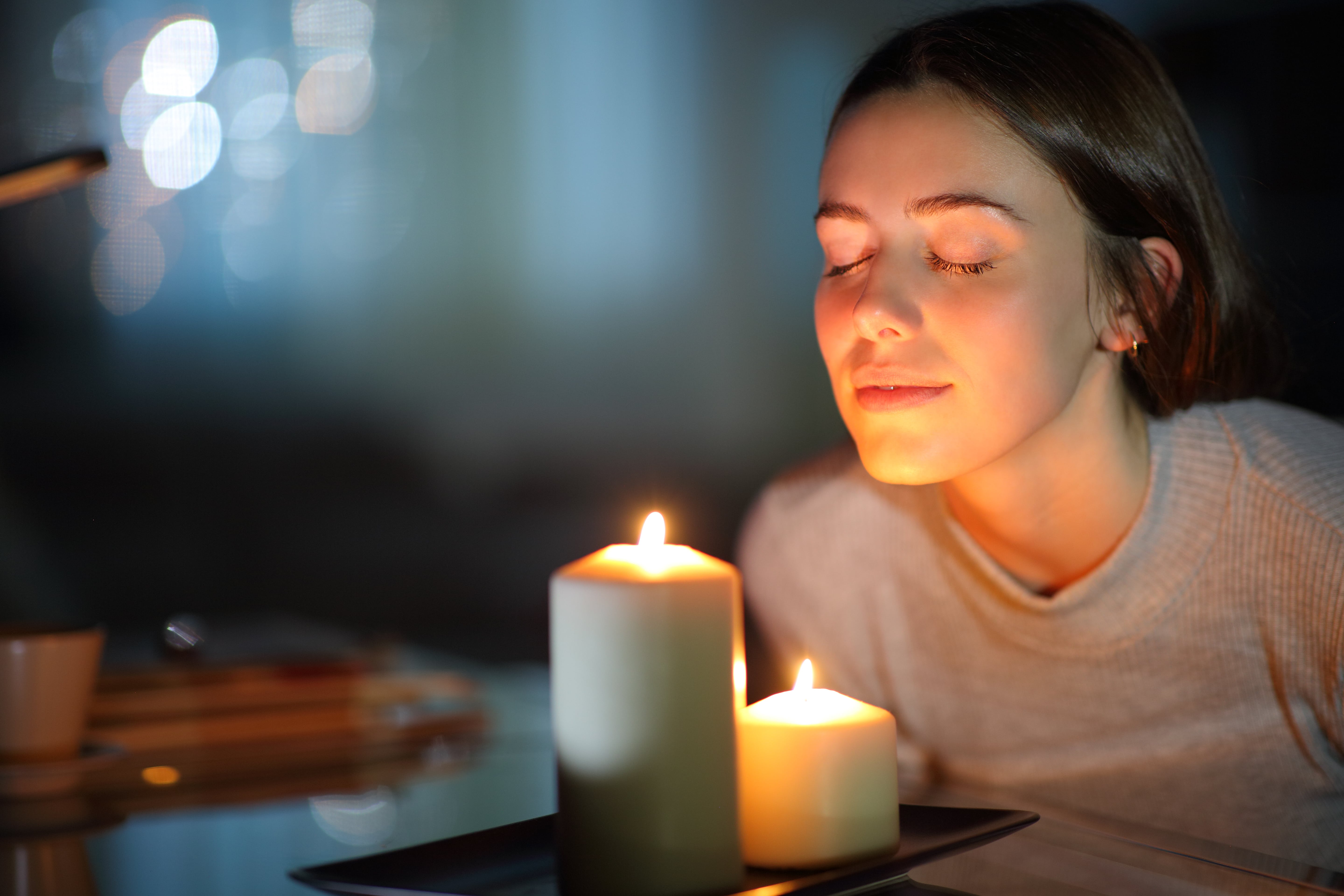 Woman smelling two lit candles