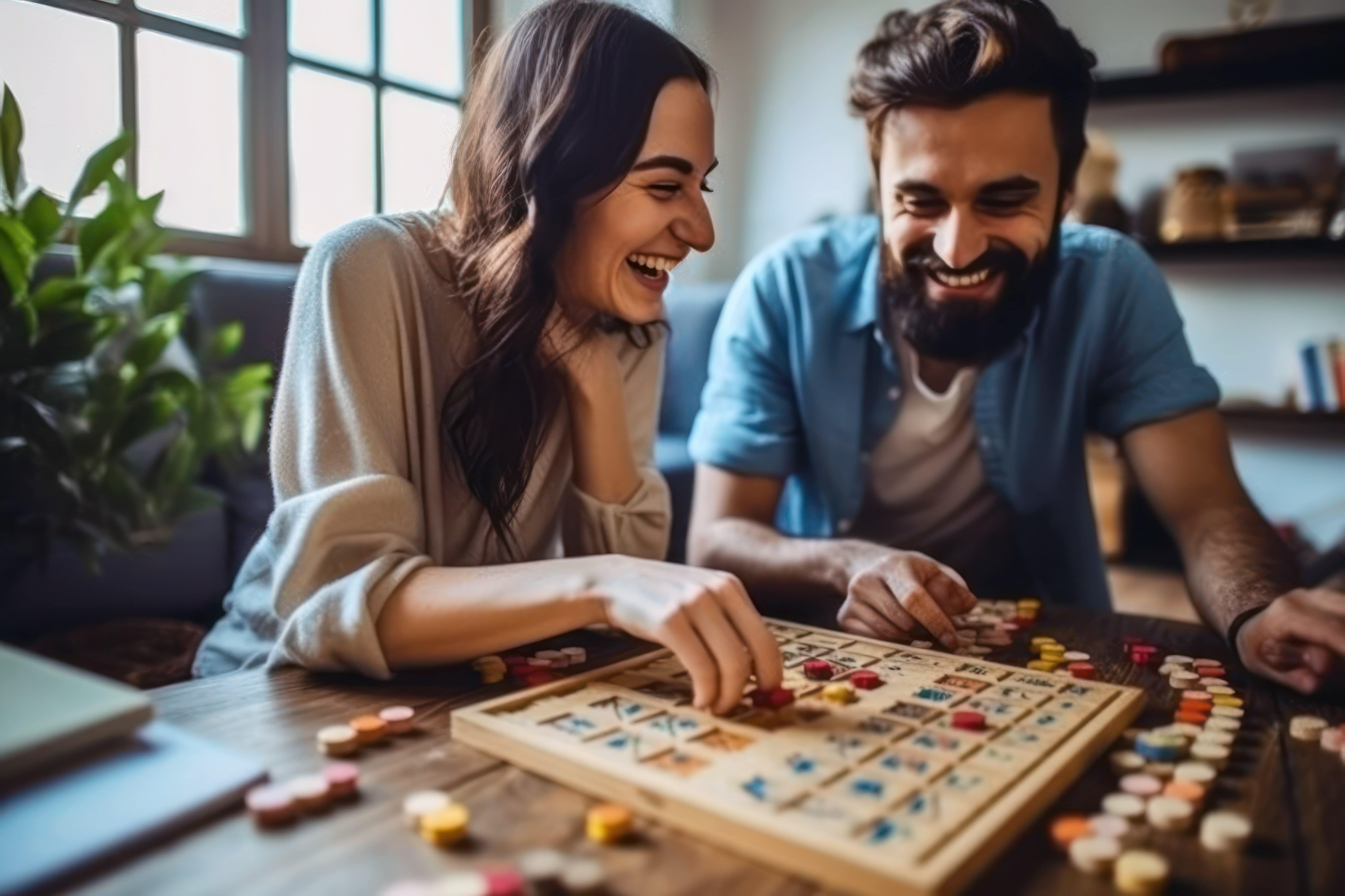 A couple smiling as they enjoy each other's company while having a board game date night at home.