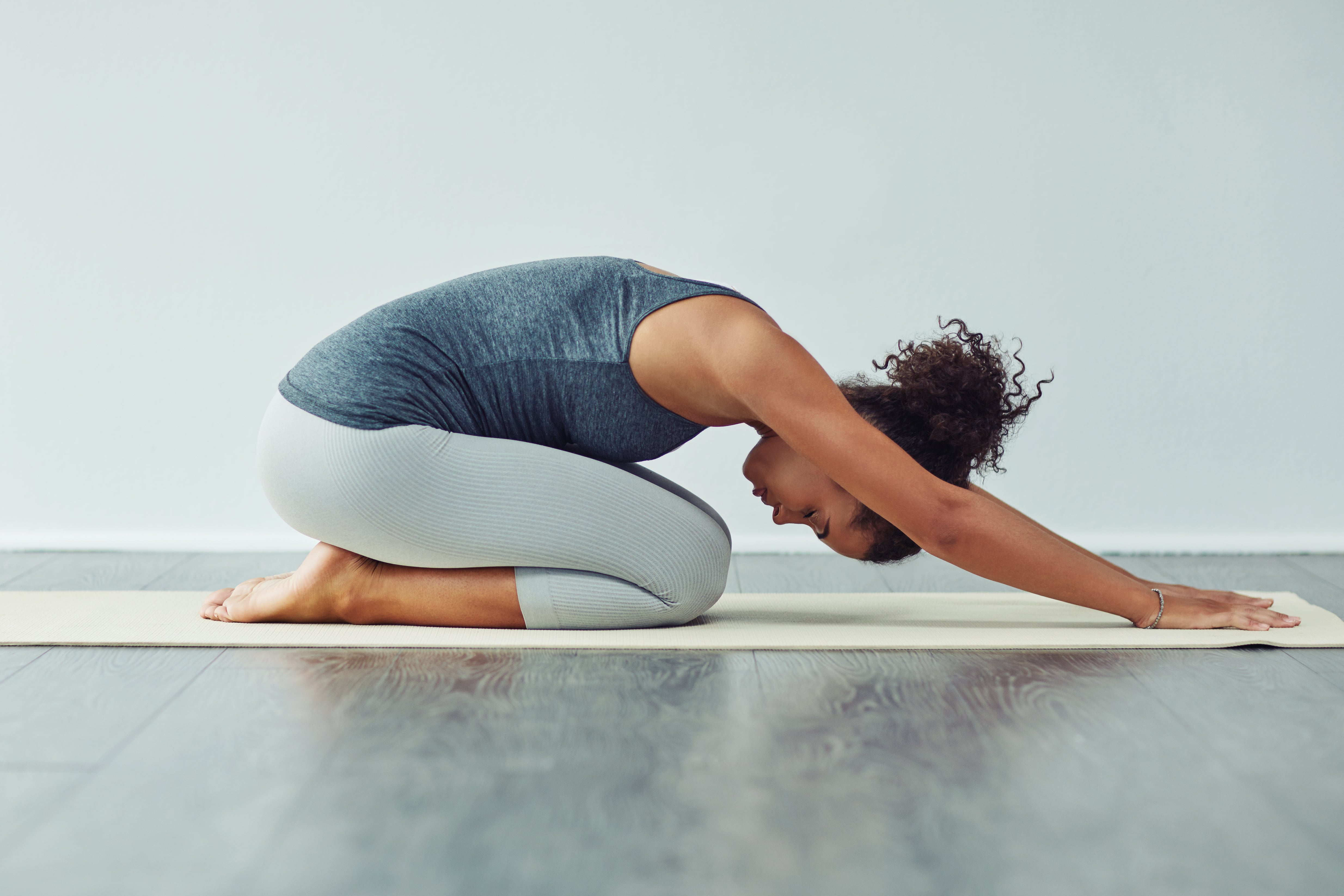 A lady positioned in the yoga child pose