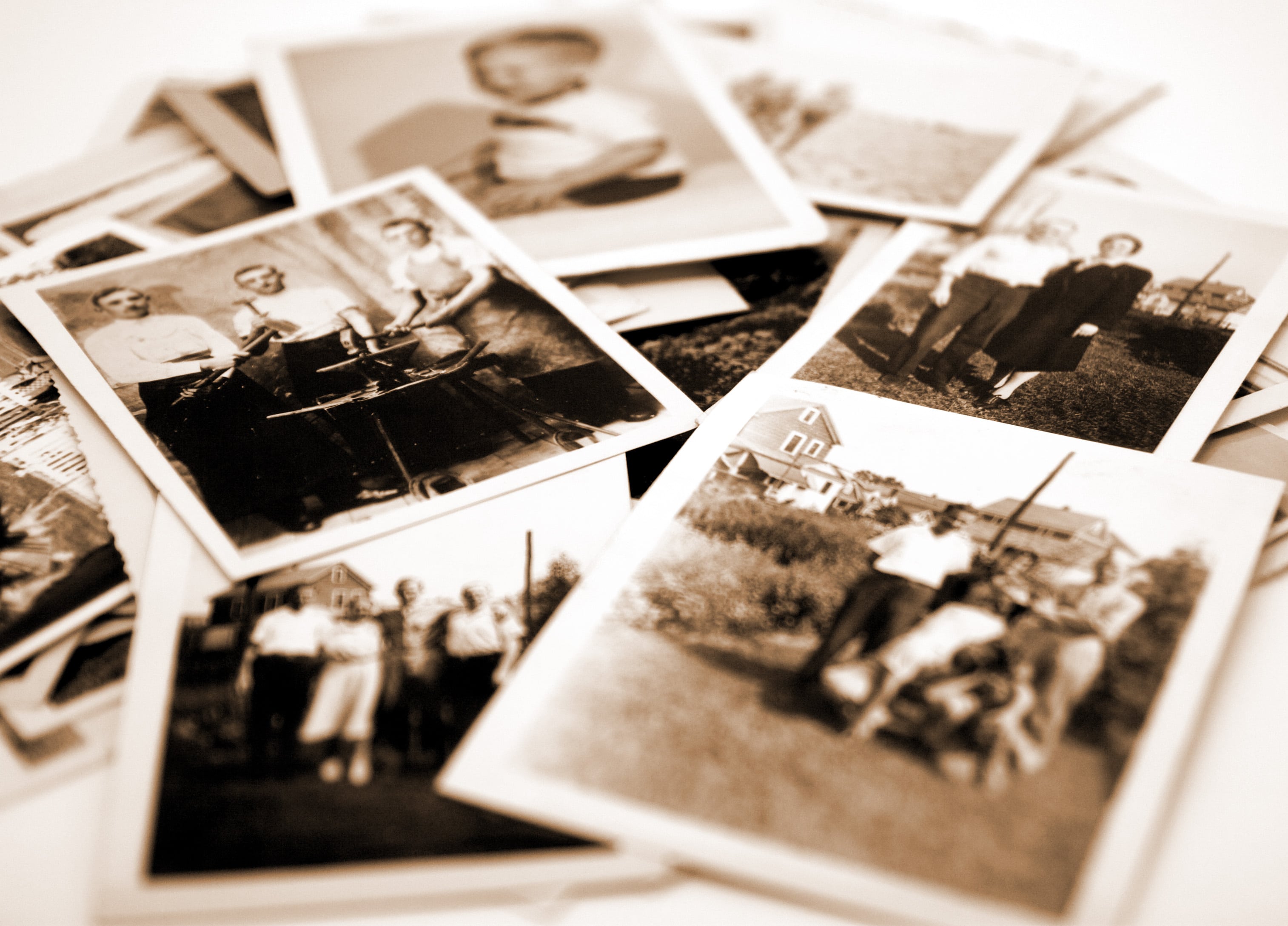 Black and White polaroid pictures are spread out on a table.