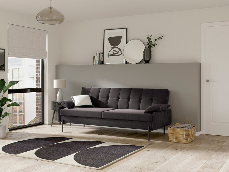 A dark grey sofa bed in a contemporary minimalist room decorated in shades of grey and off-white