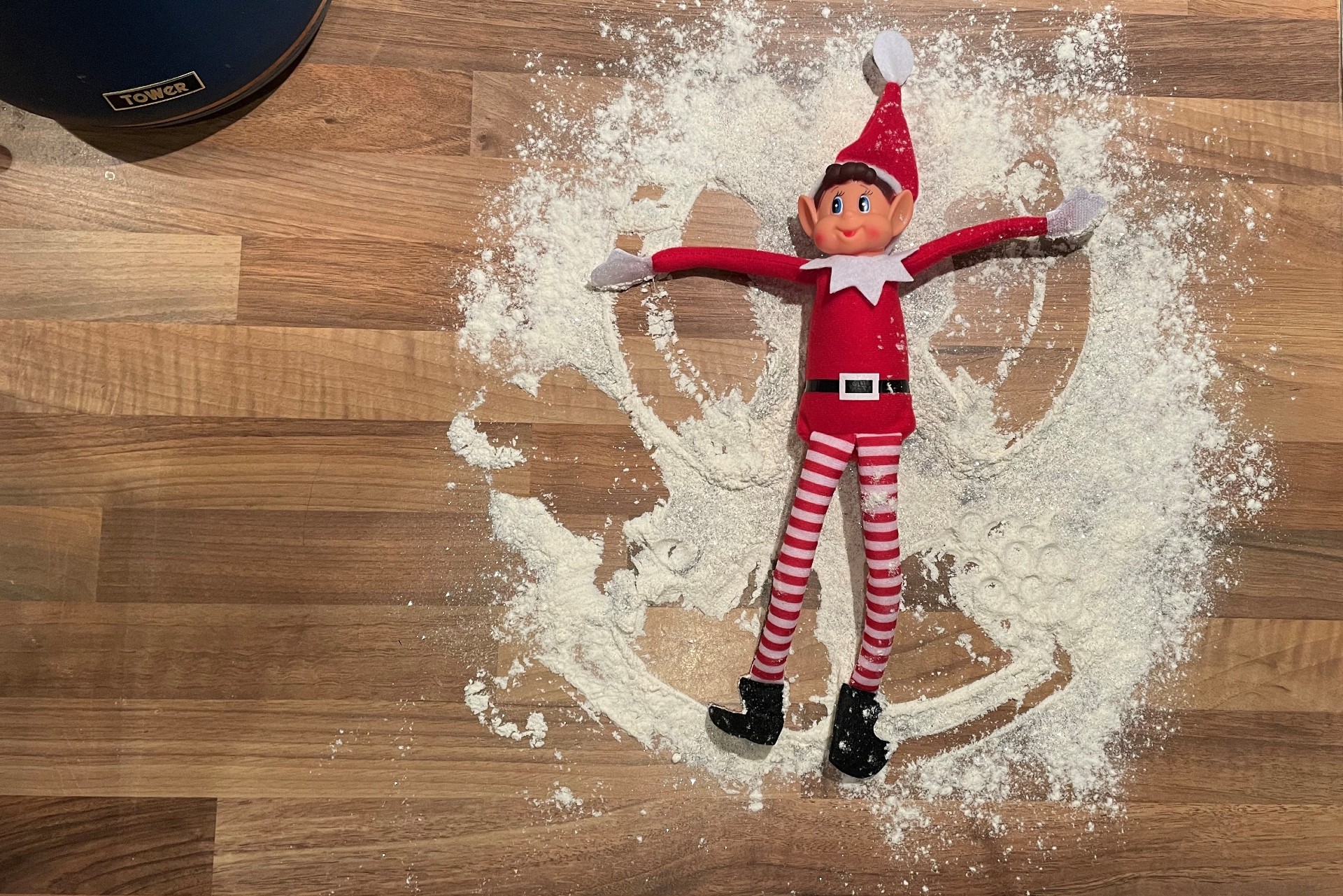 Elf on the Shelf making a glitter snow angel out of flour