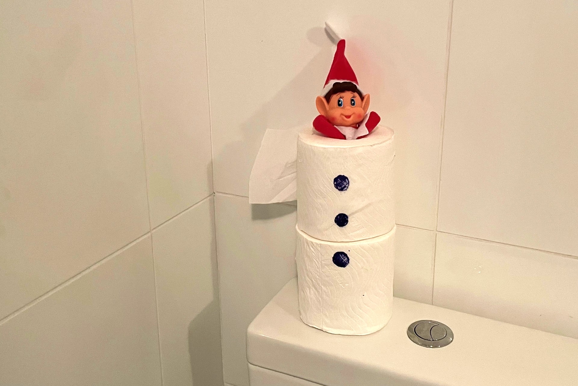 And elf squashed into 2 toilet rolls stacked on top of each other with three buttons drawn onto the body of the would-be snowman