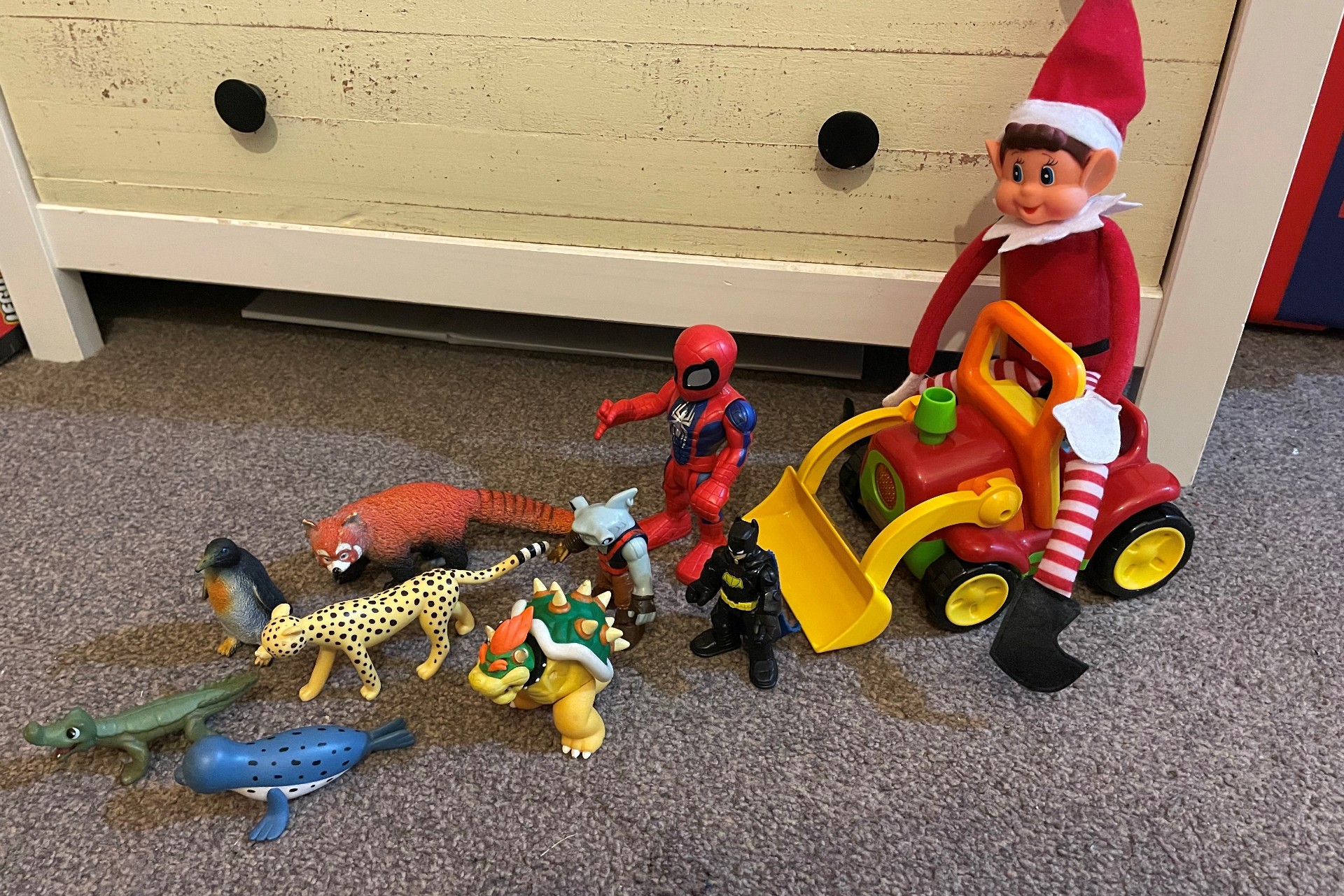 Elf on the shelf on a tractor sleigh pulled by a collection of sea creatures and action figures