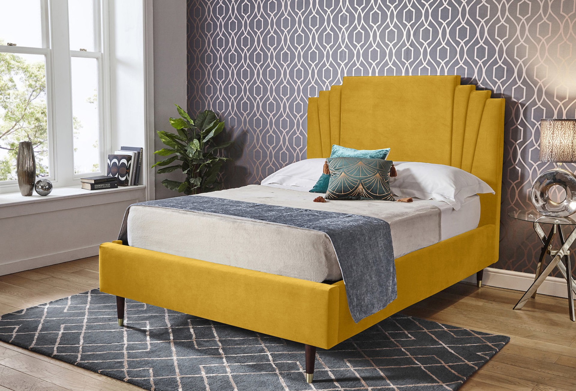 Fitzgerald Upholstered ottoman bed in mustard yellow with a maximalist printed wallpaper as the backdrop